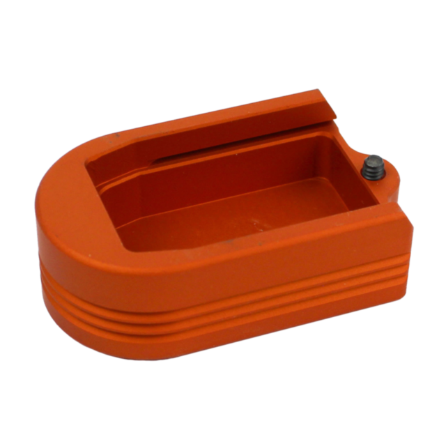 The HENNING EXTENDED MAGAZINE BASE P-10 PLUS 2 in orange is a rectangular plastic object with rounded edges and side grooves. It includes an open slot on top and a small black button or protrusion on one end for enhanced functionality.