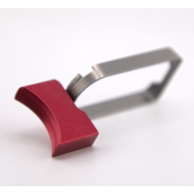 Introducing the DWX COMPACT TRIGGER ASM: This medium curved, metallic peeler features a vibrant red ergonomic handle designed for comfortable grip. The stainless steel peeling blade is positioned at the end, providing an effective contrast with the striki