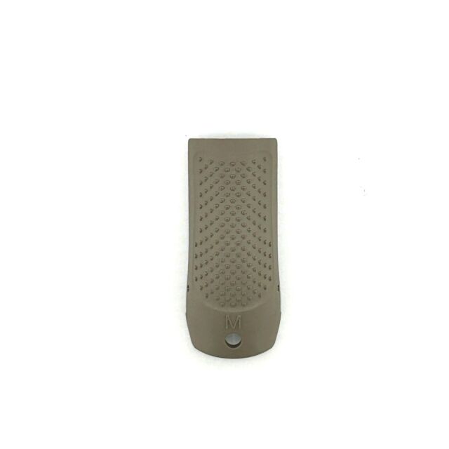 The CZ BACKSTRAP P-10 S FDE MEDIUM is a small, rectangular gray grip panel. It features a textured center with raised dots and an "M" below the texture, alongside a bottom hole. The panel is oriented vertically against a white background.