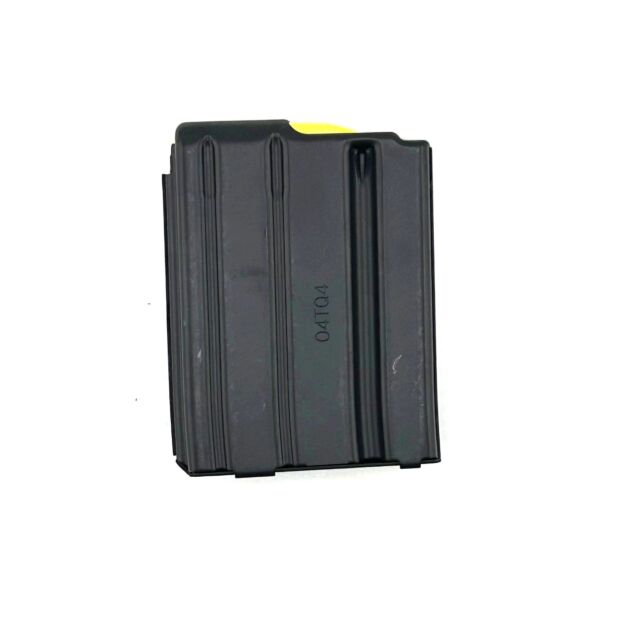 A black rectangular metal MAG CZ 805 BREN .223/5.56, designed for AR platforms, features ridged sides and lies on a white surface. The top edge has a yellow marking, and "04TQ4" is printed on it.