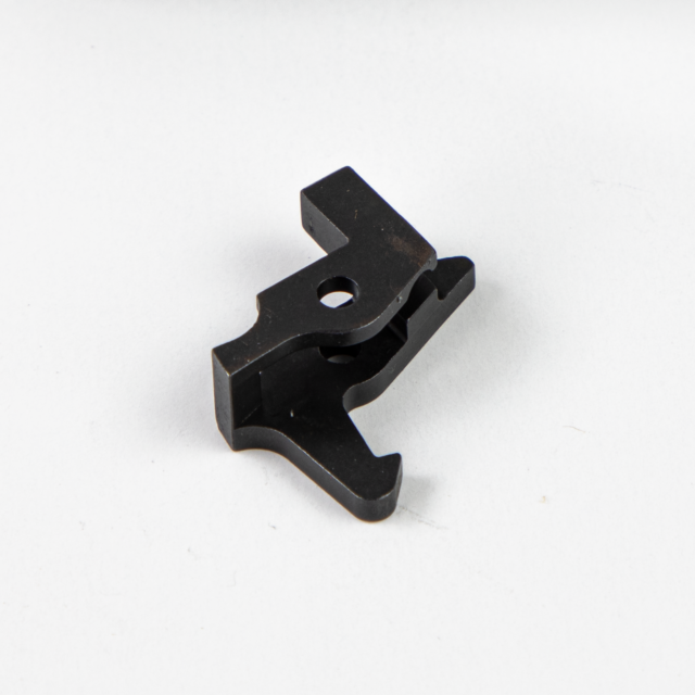 The SEAR BREN 2 is a small, black, metal bracket featuring a central hole and protruding edges, resting on a plain white surface.