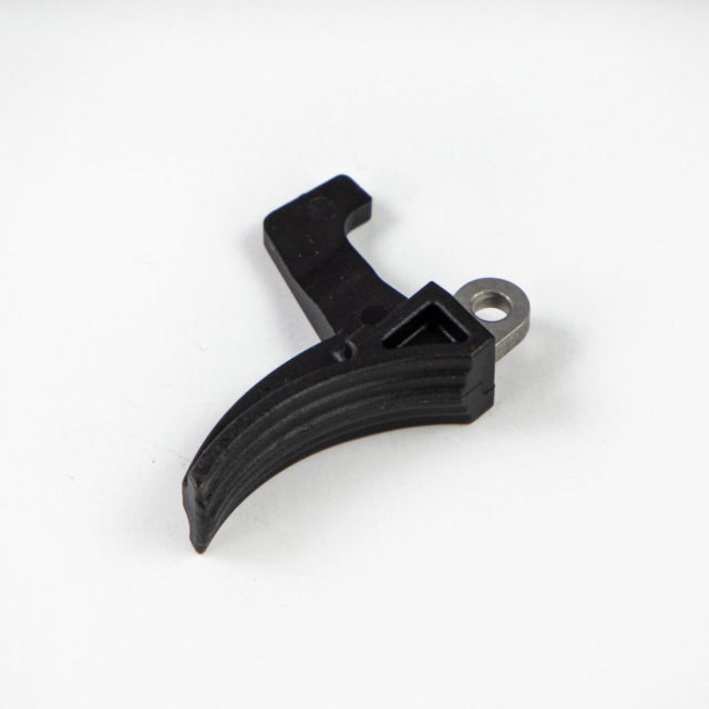 The product is the TRIGGER BREN 2, a black L-shaped mechanical part featuring a textured grip and a silver cylindrical attachment point, set against a white background.