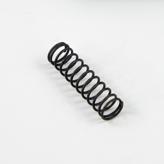 A PISTON SPRING BREN 2, finished in black metal and tightly wound into a spiral structure, is displayed diagonally against a plain white background.