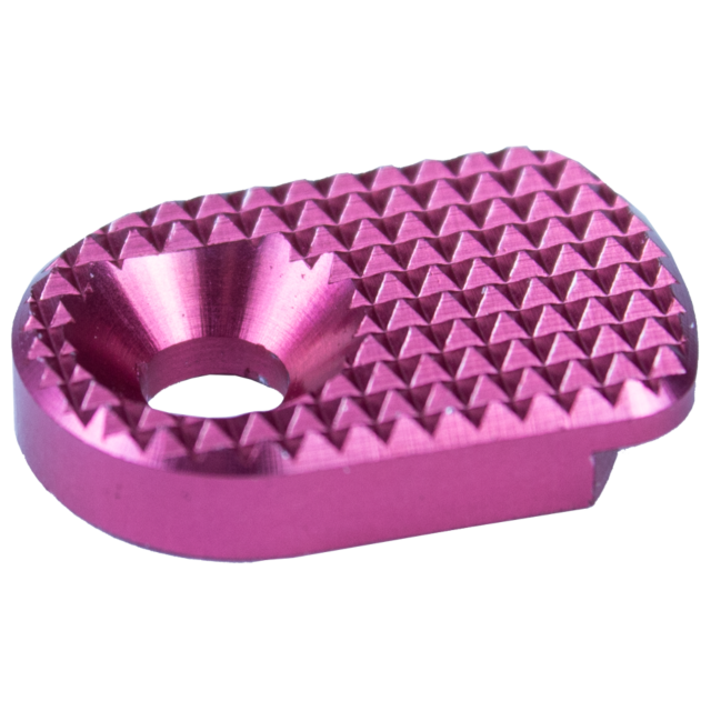 A close-up of the MAGAZINE CATCH PADDLE SHADOW 2 PINK, showcasing its compact, oval shape with a textured diamond-patterned metallic pink surface and a circular hole in the center.