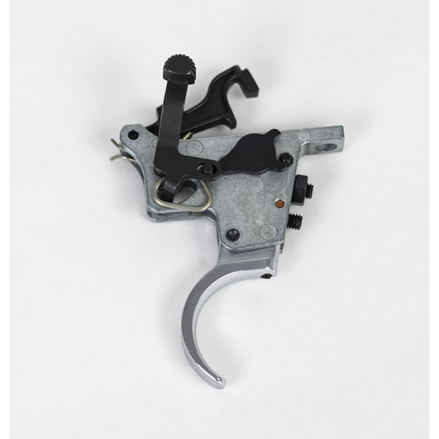 Close-up of the TRIGGER ASSEMBLY SET 457 showcasing its various components, including a curved trigger and two black adjustment screws on a white background.