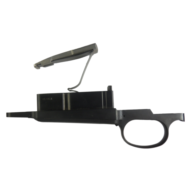 The TRIGGER GUARD COMPLETE 6.5X55 is a black trigger assembly component that includes a magazine release lever, a rectangular magazine well, and an integrated trigger guard. The raised lever makes it ideal for 6.5x55 configurations.