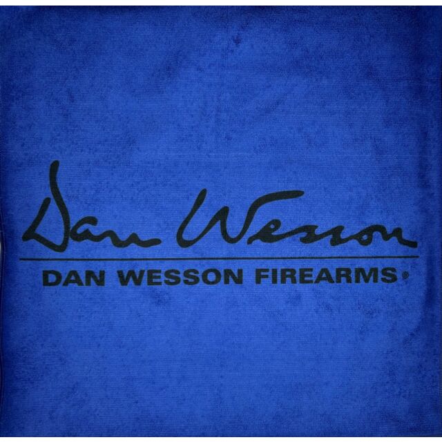 The image displays the DW logo on a BLUE MICROFIBER 16"X16" DW LOGO TOWEL. The logo showcases a stylized signature of "Dan Wesson" above the bold capitalized text "DAN WESSON FIREARMS," all set against an eye-catching blue background.
