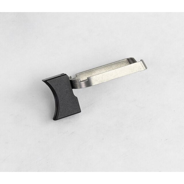 A DWX FULL SIZE TRIGGER ASM, MED. SOLID, B lies on a white surface. It features a curved black plastic grip at one end and a flat, rectangular metal body. Its overall design is simple and functional.