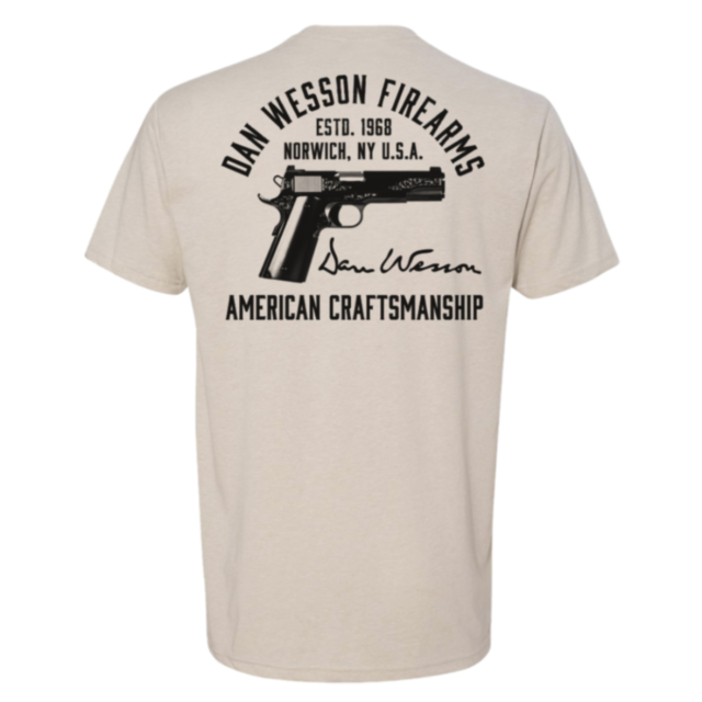 The Dan Wesson Heirloom Tee in sand (size S) features a handgun graphic and text: "Dan Wesson Firearms, Estd. 1968, Norwich, NY U.S.A., Dan Wesson, American Craftsmanship.